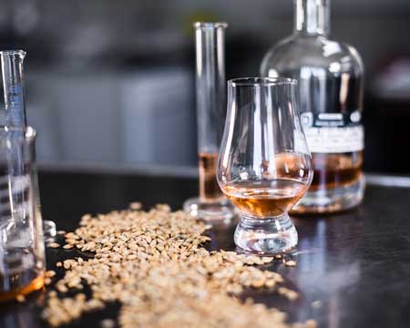 malt and glasses with whiskey on a table